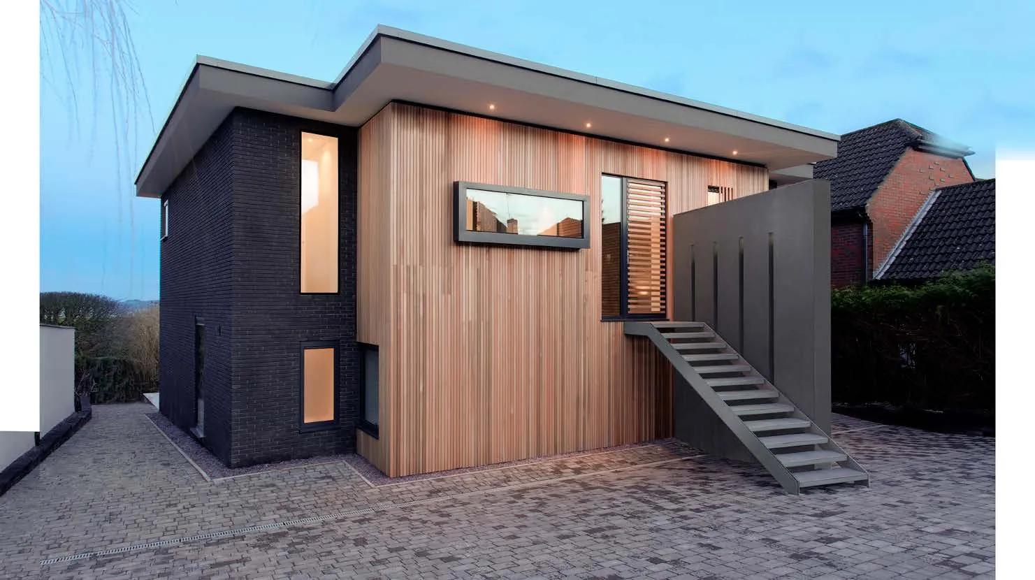 Timber-clad garden building with dark aluminium glazed doors
