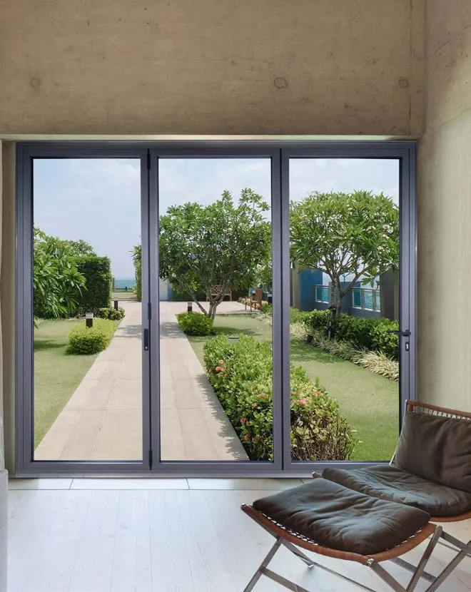 Closed aluminium bi-fold door looking down a garden path